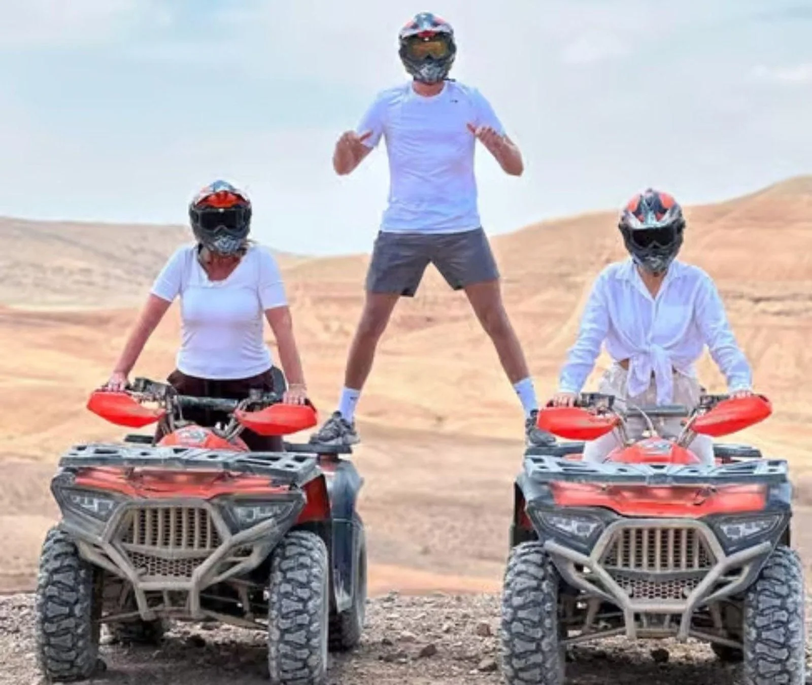 Three quad bike riders posing on their quads in the Agafay Desert